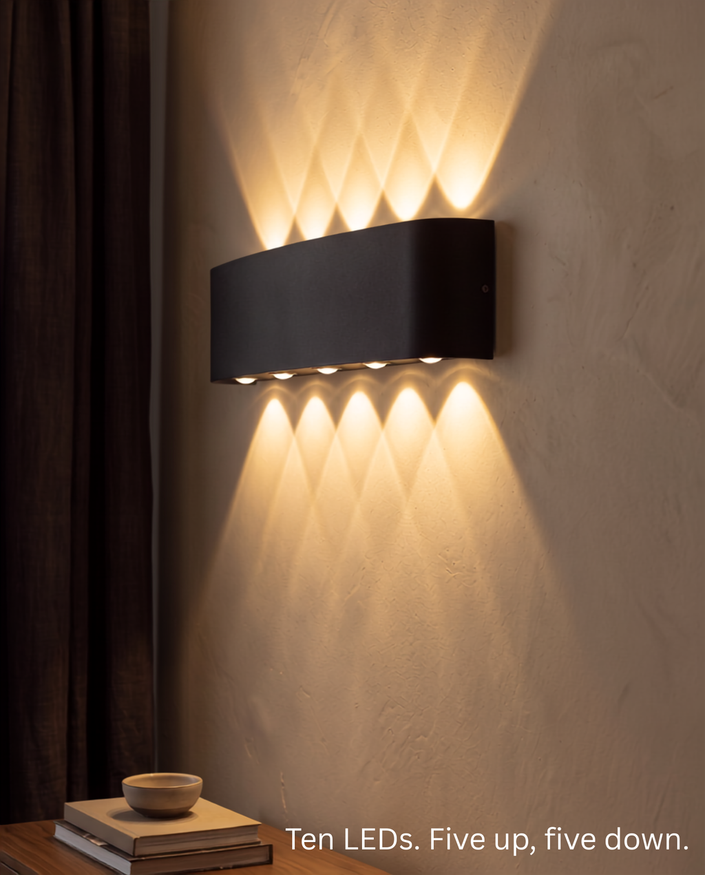Close view of the Aura Beam wall light showing its ten LEDs, five throwing light up and five down