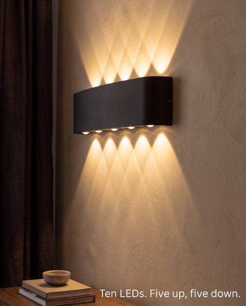 Close view of the Aura Beam wall light showing its ten LEDs, five throwing light up and five down