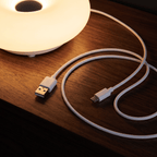 Close view of the Halo donut lamp on wood with its USB power cable coiled beside it