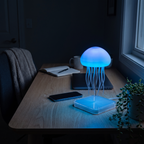 Jelly jellyfish lamp glowing blue on a desk at night beside a notebook and phone