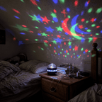Starlull projector covering an attic bedroom ceiling and walls with multicoloured stars and moons