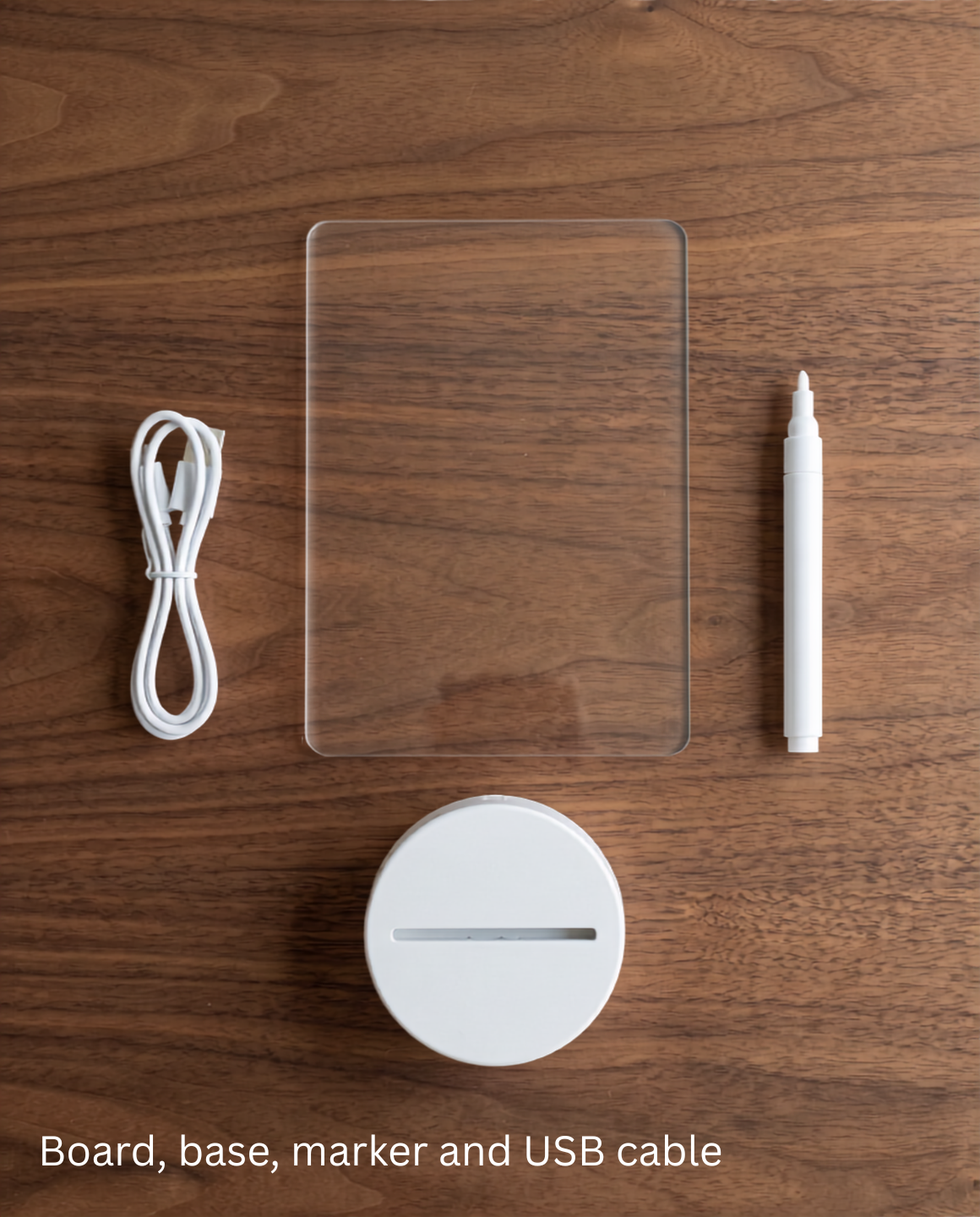 Everything in the NoteGlow box laid out on walnut: acrylic board, round LED base, chalk marker and USB cable
