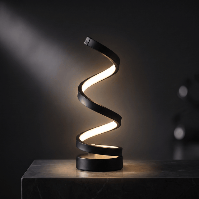 Spira LED spiral table lamp lit against a dark studio background, showing the twisting ribbon form