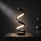 Spira LED spiral table lamp lit against a dark studio background, showing the twisting ribbon form