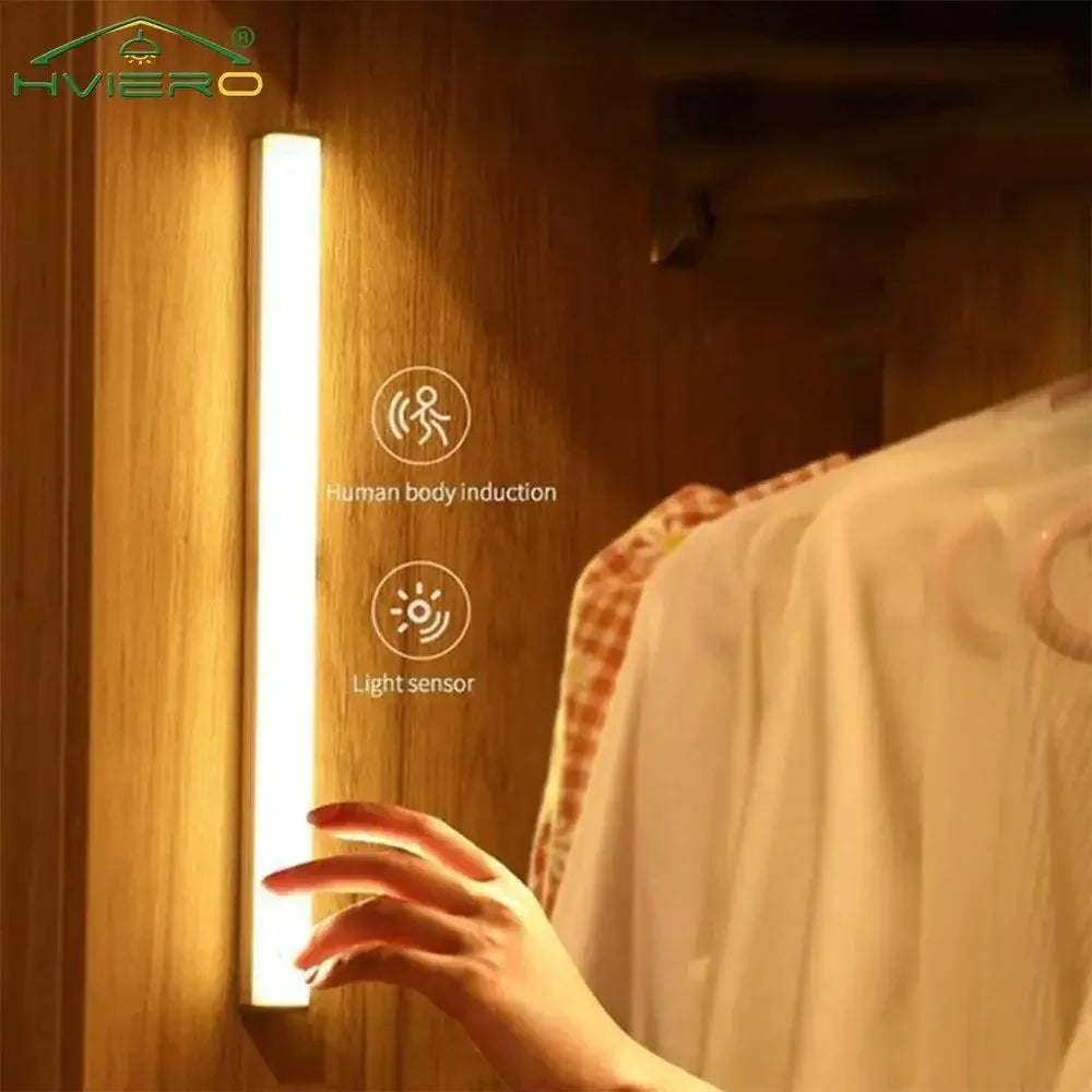 Nook Light bar lighting a wardrobe rail as a hand reaches for clothes, with motion and light sensor icons