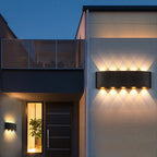 Aura Beam wall lights lighting the entrance and doorway of a modern house at night
