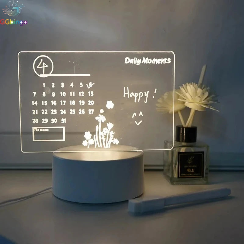 NoteGlow style acrylic message board with a printed monthly calendar on a blue lit base beside a reed diffuser